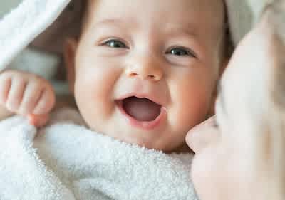 Baby wrapped in towel.